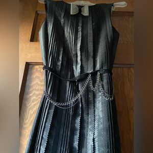 Julie Haus Elegant Black Pleated Cocktail Dress with Chain Detail.